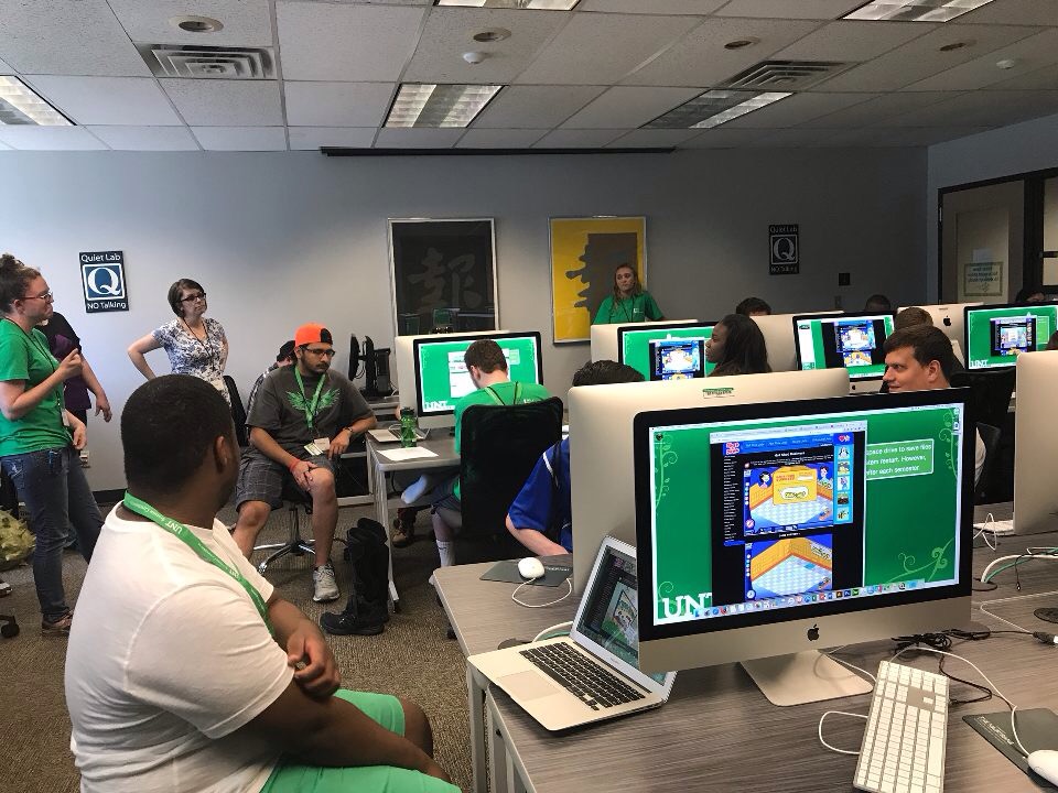 Group of participants, in a computer lab, listening to a guest speaker. 