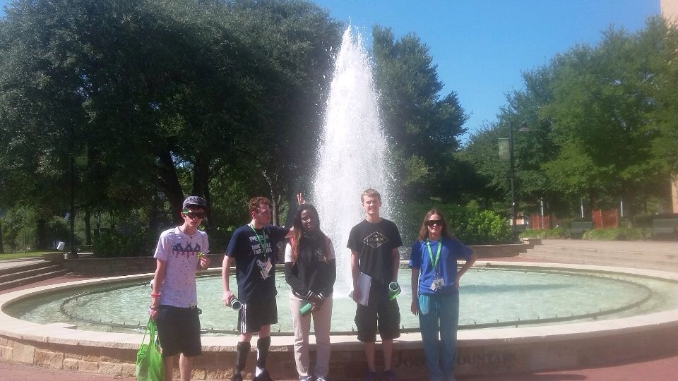Group of five participants standing in front of a fountain at UNT.