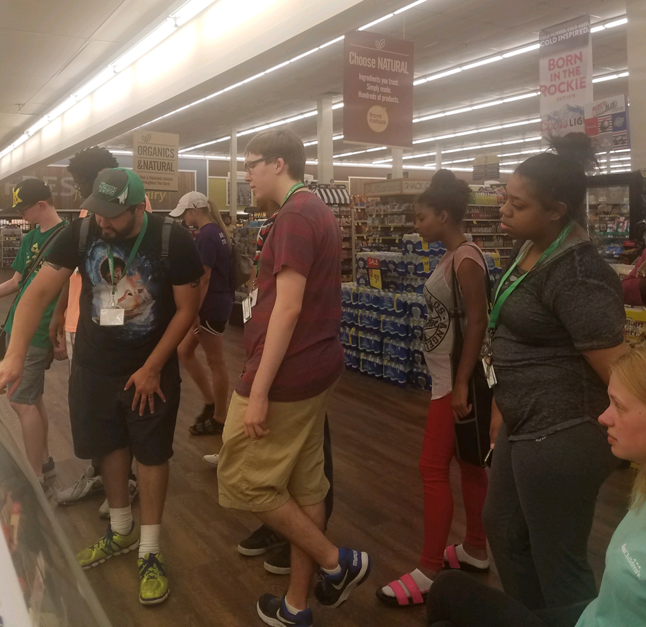 Group of participants at a grocery store, looking at food.