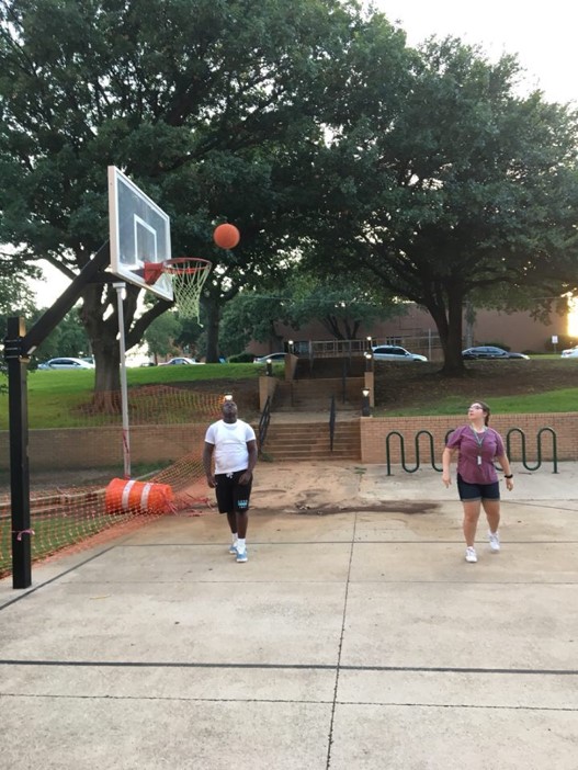 Two participants playing basketball outside.