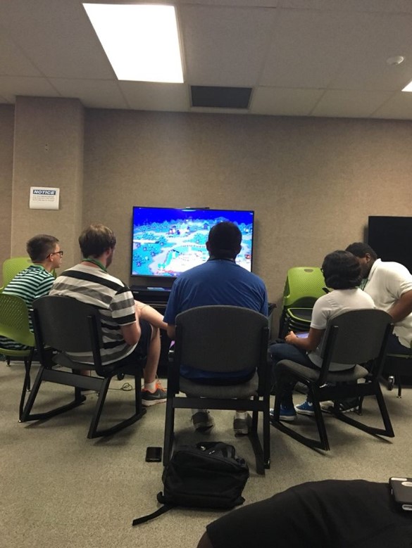 Five participants playing a video game on the television.